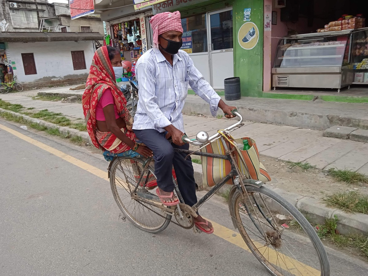 श्रीमतीलाई साइकलमा राखेर अस्पतालबाट फर्किँँदै लक्ष्मण मेहता। तस्बिर : पारूल क्षेत्रीको फेसबुकबाट