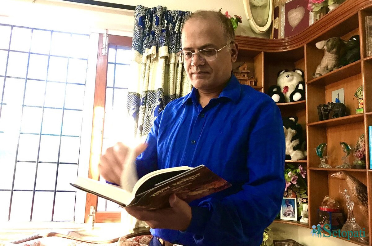 हालै प्रकाशित आफ्नो किताब 'मुकाम रणमैदान' पल्टाउँदै लेखक मोहन मैनाली। तस्बिर: सुदीप श्रेष्ठ/सेतोपाटी